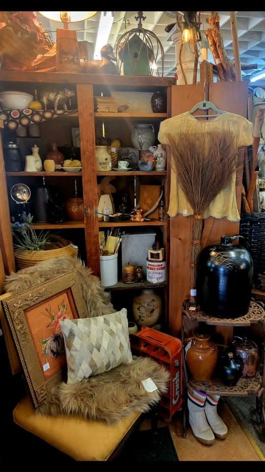 Warm pine shelving at M & M packed with honey ceramics, stoneware jugs, and vintage finds